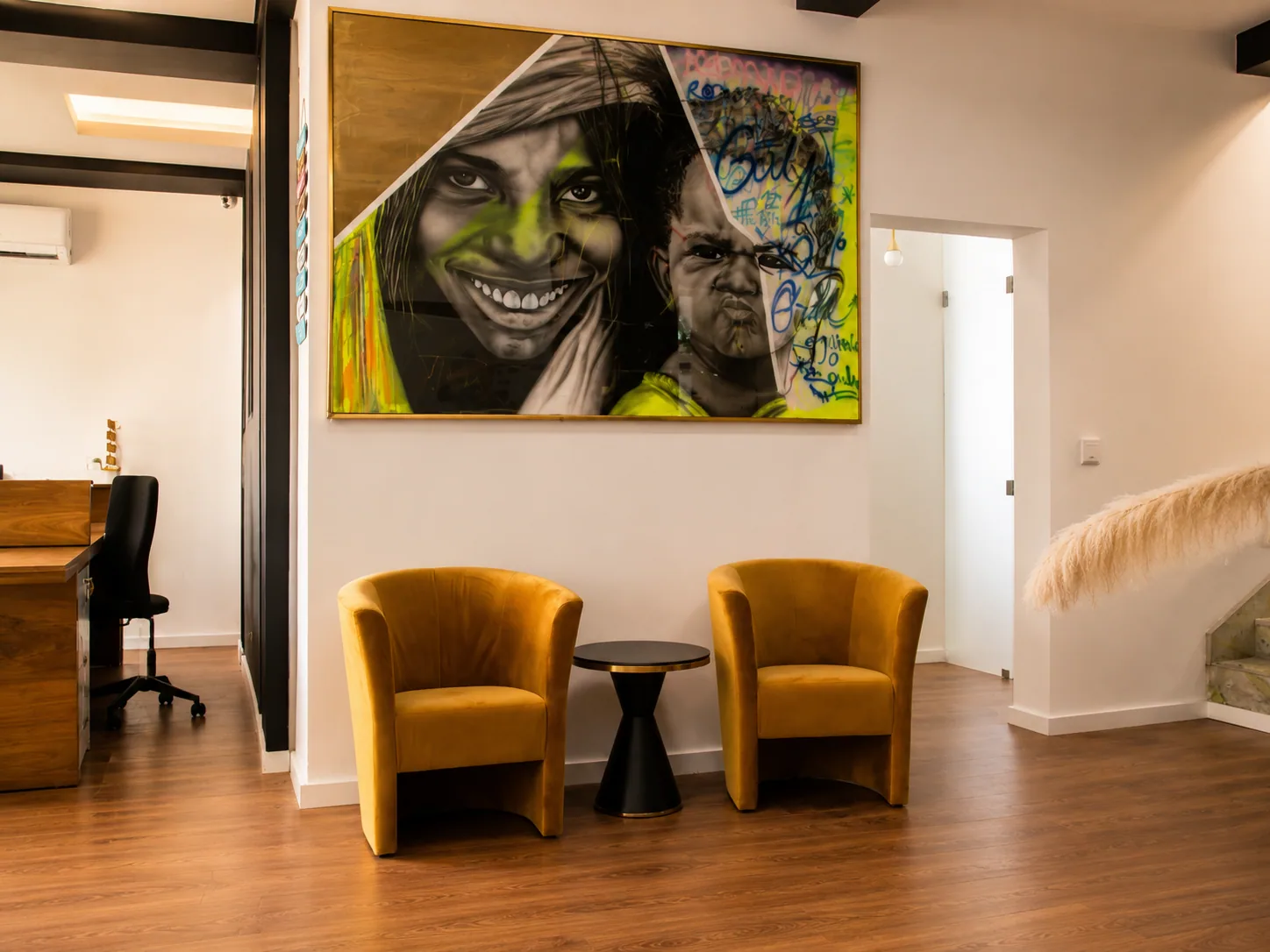 Zona de espera do GBC com poltronas douradas e arte angolana
