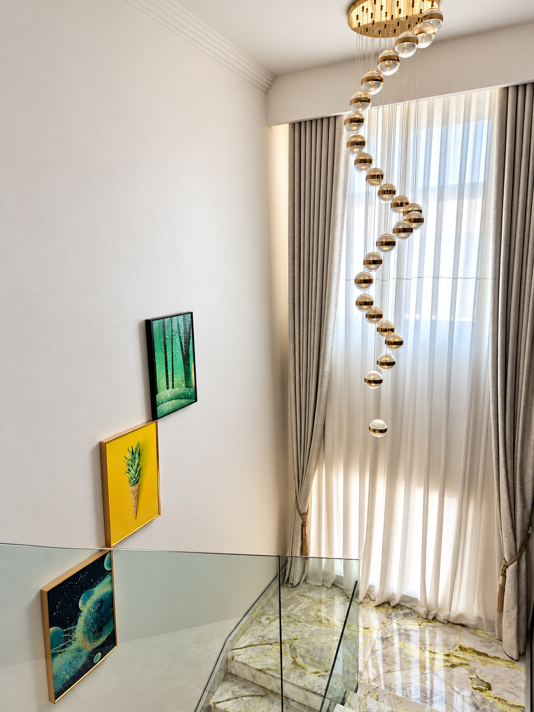 Escadaria com lustre dourado, cortinas e quadros decorativos