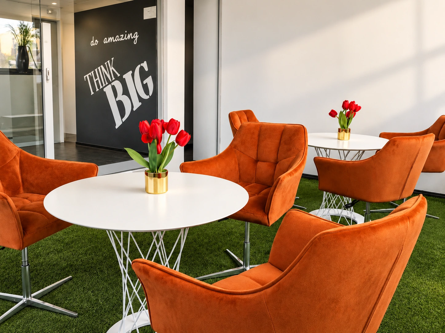 Esplanada do GELS Business Center com mesas brancas e poltronas laranja